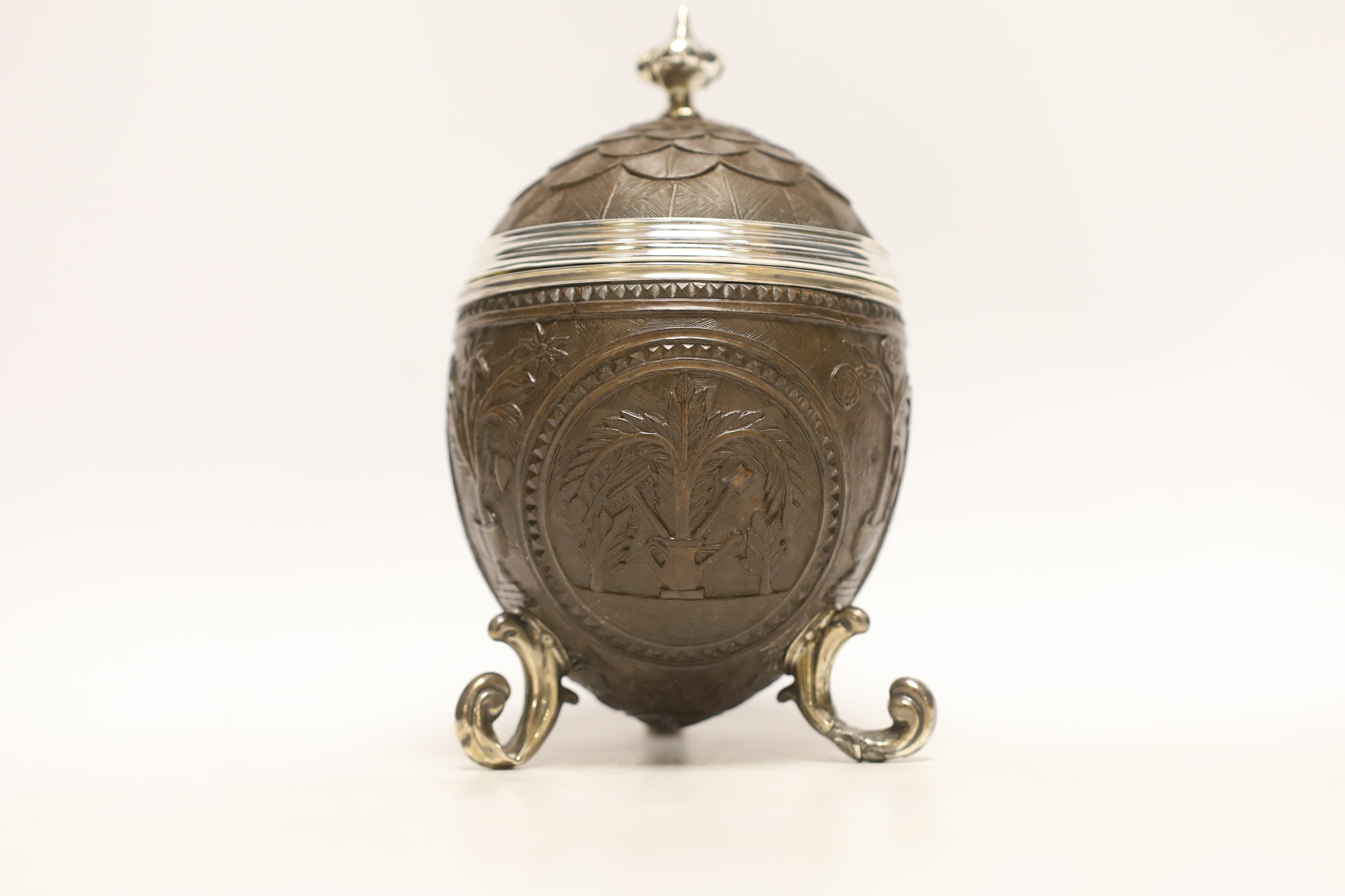 A unmarked white metal mounted coconut cup, on three scroll feet, height 17.4cm.